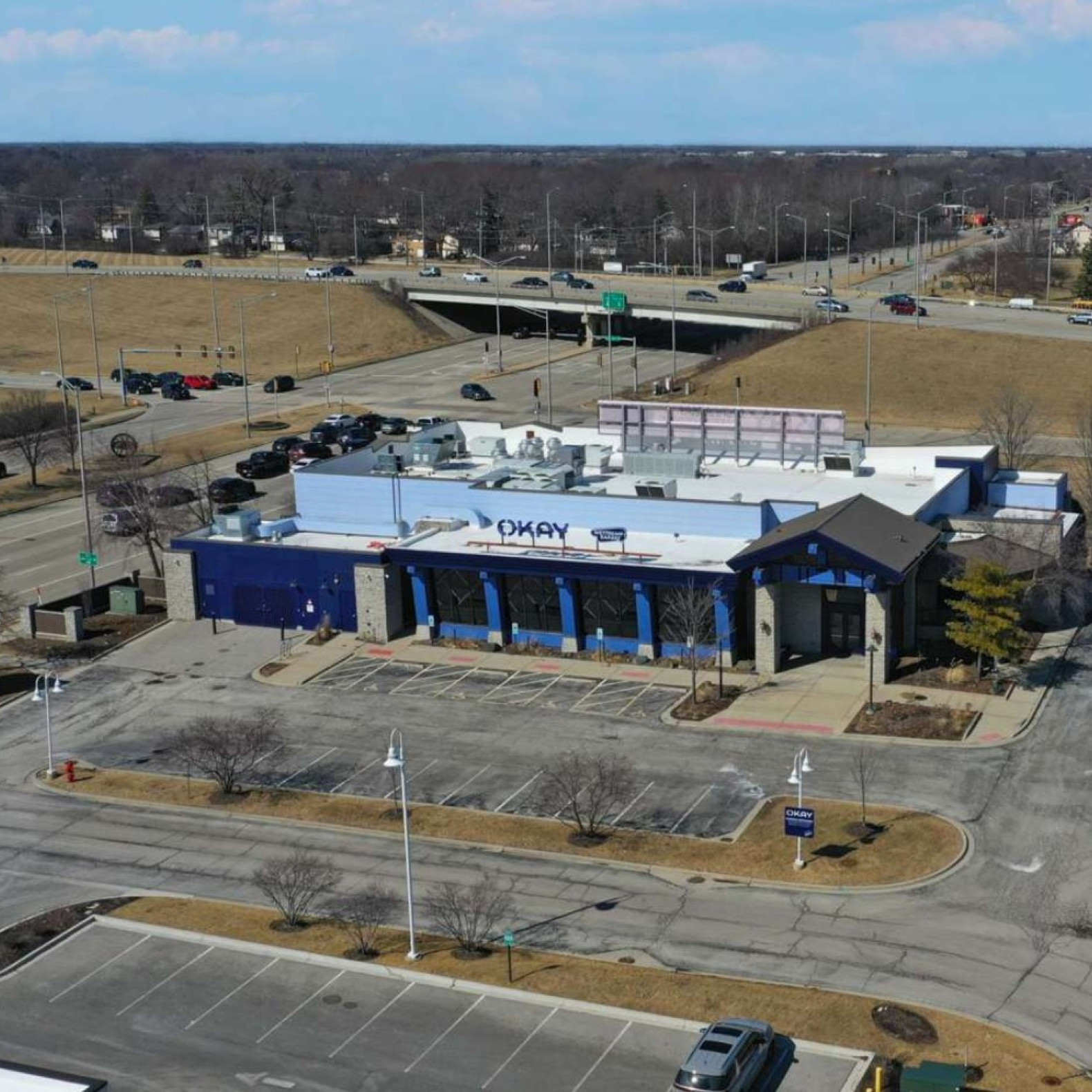 Okay Restaurant Building aerial view of building, lot and nearby highway overpass
