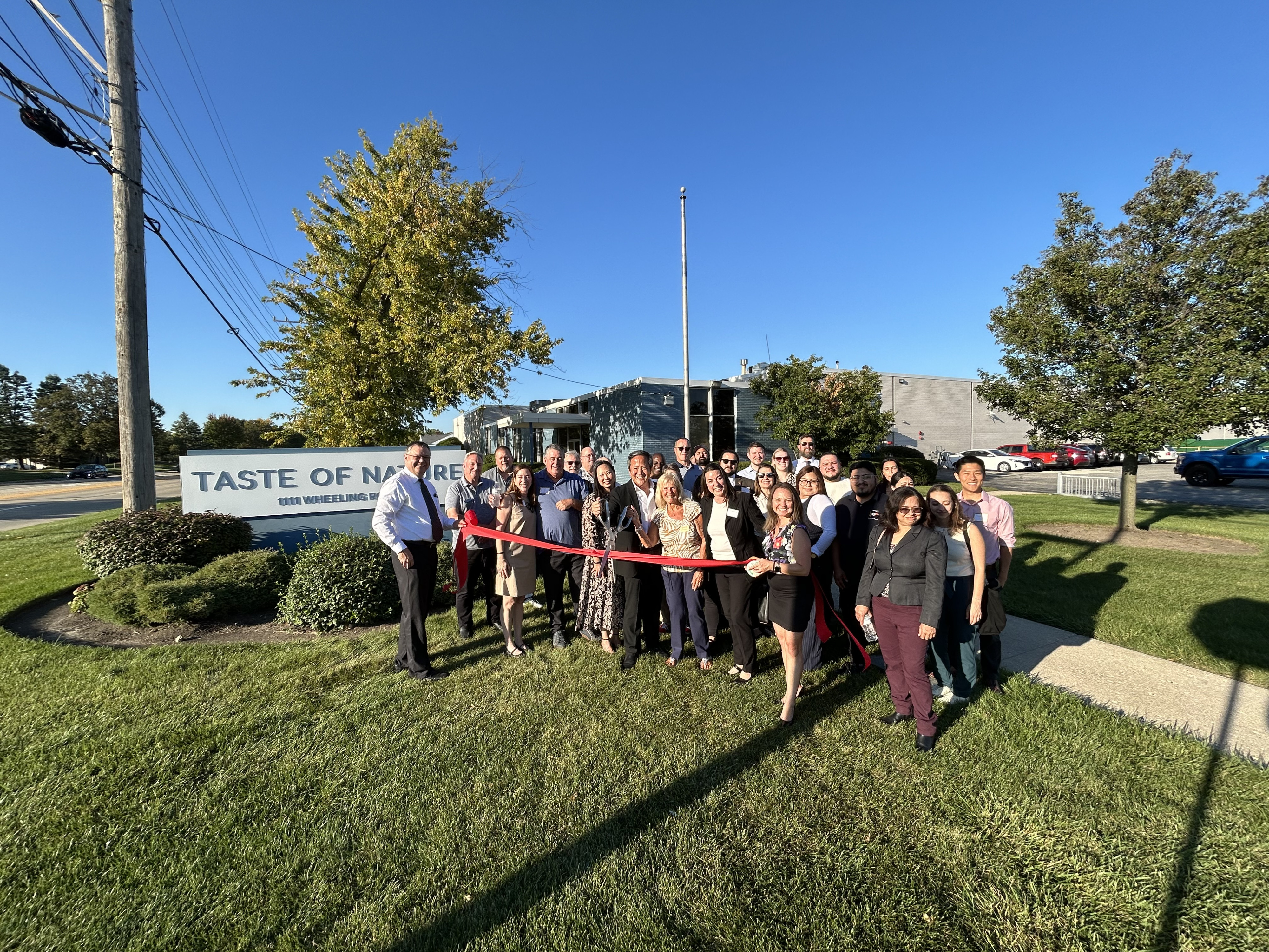 Taste of Town owners cut ribbon at ribbon cutting and guests celebrate
